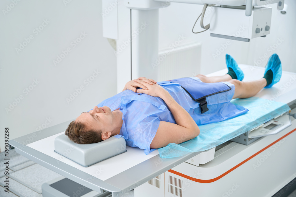 Man getting knee x-ray with digital radiography equipment Man getting knee x-ray with digital radiography equipment