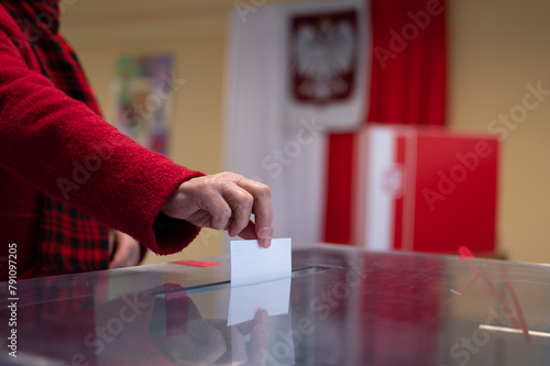 voter's hand putting the vote into the ballot box. photo