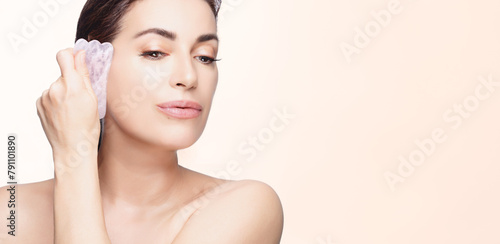 Woman Practicing Facial Skincare Routine with Gua Sha Stone