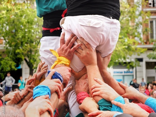 Detail of the base of a human tower. Raised hands of the castellers forming the pinya (base) and supporting the tower