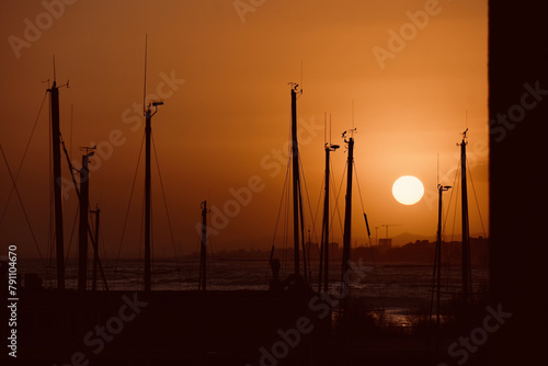 Silhouettes of ships moored in the harbor with a beautiful sunset sky.