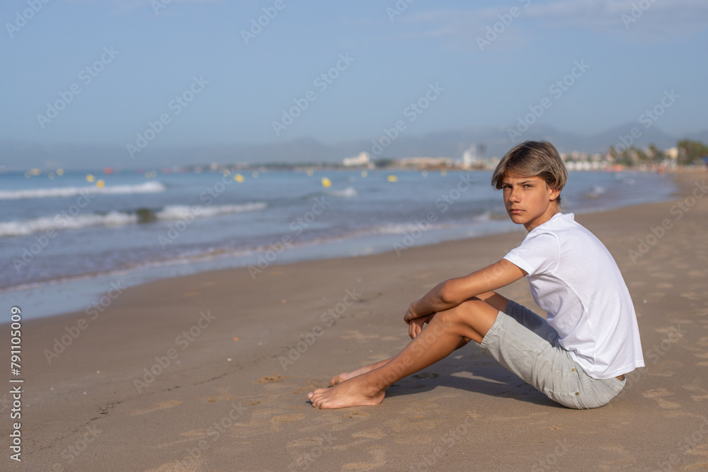 Handsome teenager boy sitting at the beach and enjoy a summer vacation. Handsome teenager boy sitting at the beach and enjoy a summer vacation.