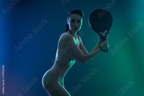 Naked padel tennis player with racket on tournament. Woman athlete with paddle racket on court at open tour. Neon colors. Sport concept.