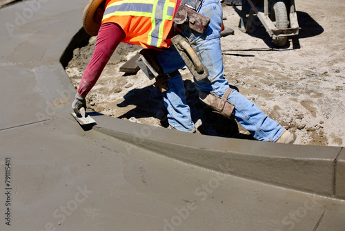 concrete worker puts final touch on wet concrete
