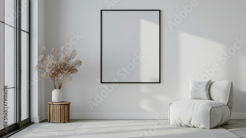 habitacion minimalista con gran ventanal, decorado con un cuadro blanco vacio sobre pared clara, sillon blanco textil adornado con cojines  y mesita redonda de madera con jarrón y planta de interior photo