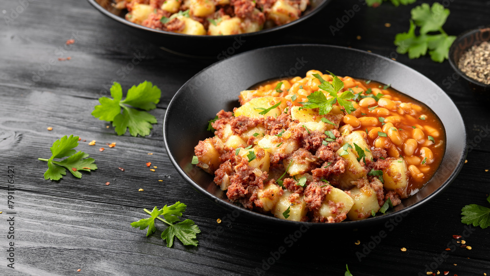 Corned beef hash with potatoes and beans in tomato sauce. Corned beef hash with potatoes and beans in tomato sauce.