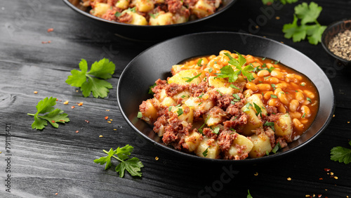 Corned beef hash with potatoes and beans in tomato sauce. photo