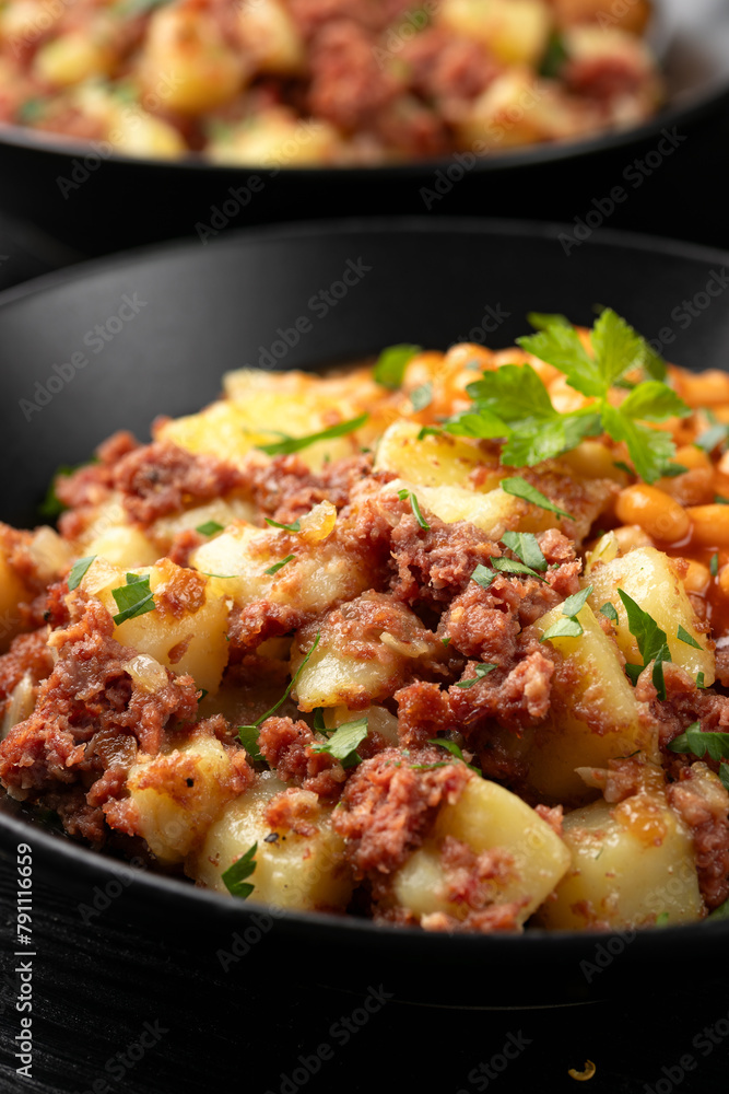 Corned beef hash with potatoes and beans in tomato sauce. Corned beef hash with potatoes and beans in tomato sauce.