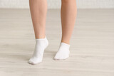 Woman in socks walking on laminate floor at home, closeup