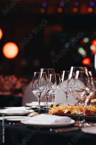 Beautifully organized event - round served table banquet ready for guests, round decorated table with empty plate, glasses, forks, napkin. Elegant dinner table 