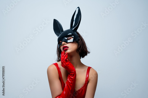 Photo of attractive woman touch sensual face skin rabbit mask red leather clothes isolated on light gray background