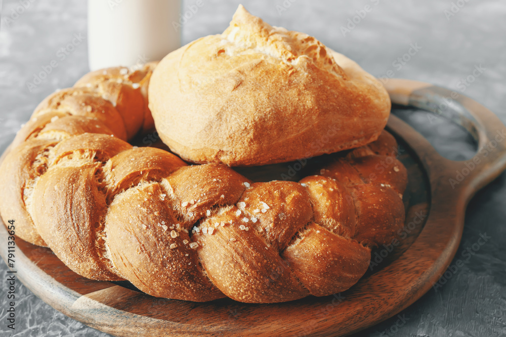 Kalach - traditional Lenten handmade bread on a village table close-up with assortment of handmade bread illuminated by natural light from a window Kalach - traditional Lenten handmade bread on a village table close-up with assortment of handmade bread illuminated by natural light from a window