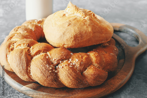 Kalach - traditional Lenten handmade bread on a village table close-up with assortment of handmade bread illuminated by natural light from a window photo