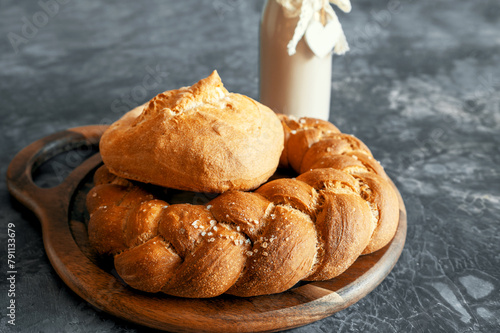 Kalach - traditional Lenten handmade bread on a village table close-up with assortment of handmade bread illuminated by natural light from a window photo