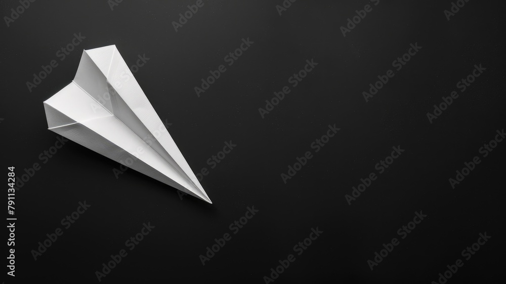 White paper airplane on dark background White paper airplane on dark background