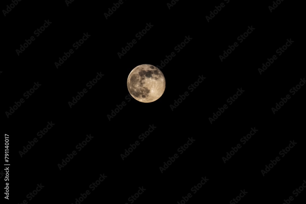 Obraz premium Enchanting Full Moon Illuminated in Night Sky with Twinkling Stars and Dark Background, Creating a Mesmerizing Celestial Image of Wonder and Awe in the Vast Universe