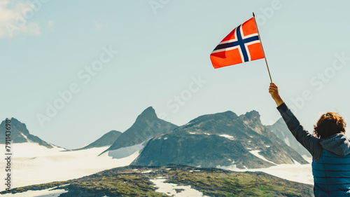 Tourist with norwegian flag in mountains photo
