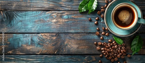 A wooden background with coffee cup and coffee beans, seen from above. photo