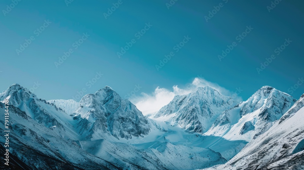 Fresh snow covering the peaks of mountains under a clear blue sky