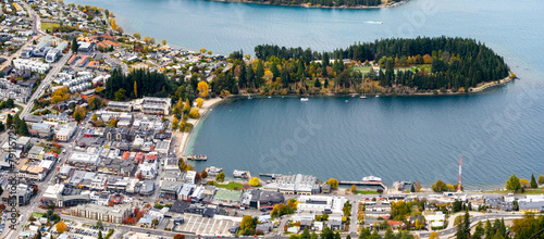Elevated panoramic view of Queenstown's town center, with buildings at the waterfront of Lake Wakatipu. The resort town in New Zealand is a popular travel destination and tourist attraction.