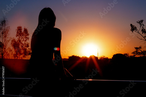 Mulher olhando o pôr do sol