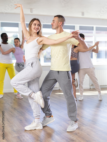 Couple male and girl rehearsing pair latino dance in dance studio