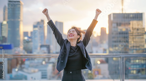 空に向かって手を広げる女性 Business woman stretching her arm to the sky