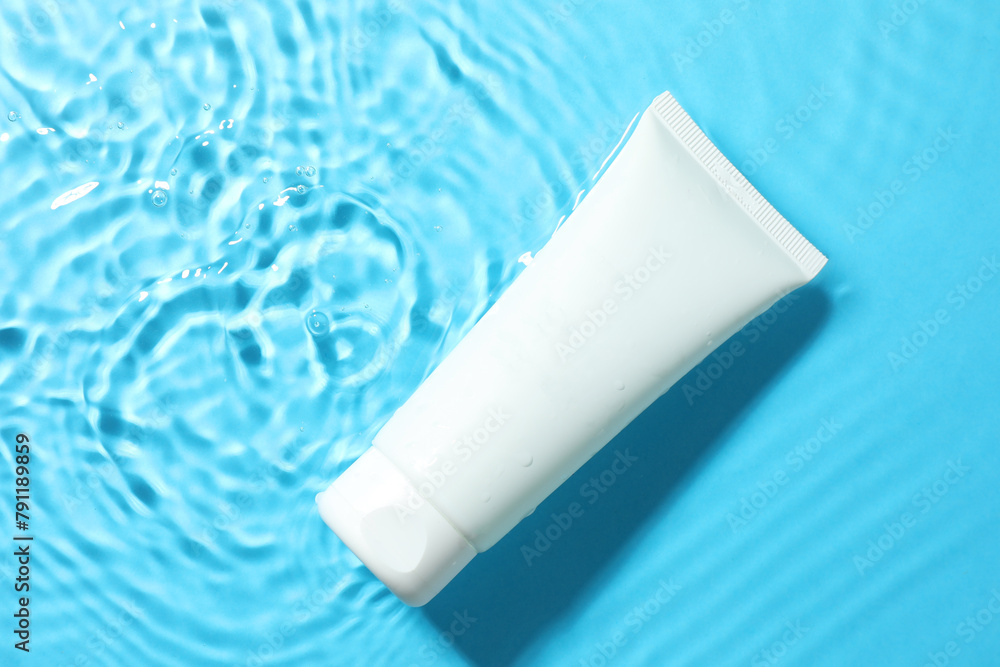 Tube with moisturizing cream in water on light blue background, top view Tube with moisturizing cream in water on light blue background, top view