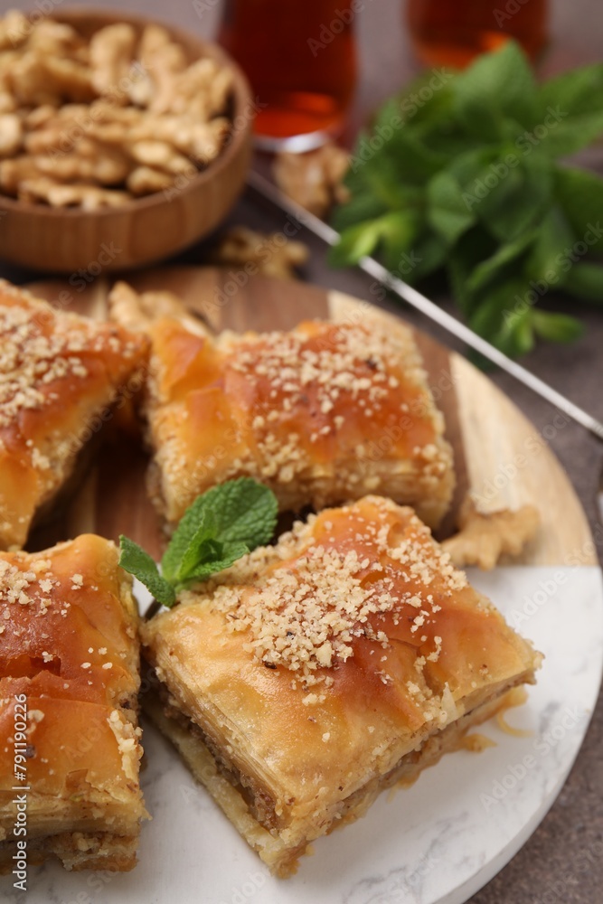 Eastern sweets. Pieces of tasty baklava on brown table, closeup Eastern sweets. Pieces of tasty baklava on brown table, closeup