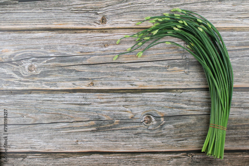 Garlic chives or Allium tuberosum on wooden table background. Fresh healthy organic green vegetable. Garlic chives or Allium tuberosum on wooden table background. Fresh healthy organic green vegetable.