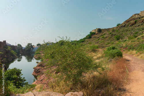 View of Mehrangarh fort from Rao Jodha desert rock park, Jodhpur, India. A lake in foreground and Mehrangarh fort in the background, with rocky landscape of the desert park.