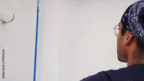 Man Using Paint Brush In Painting Interior Wall Of House Room. closeup shot photo