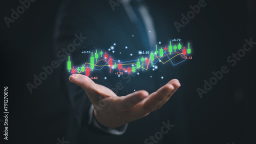 A man wear suit is holding a hand up to show a graph of stock exchange prices in concept of investment, market trend forecast and financial analyze.