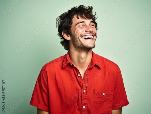 A man in a red shirt is smiling and laughing
