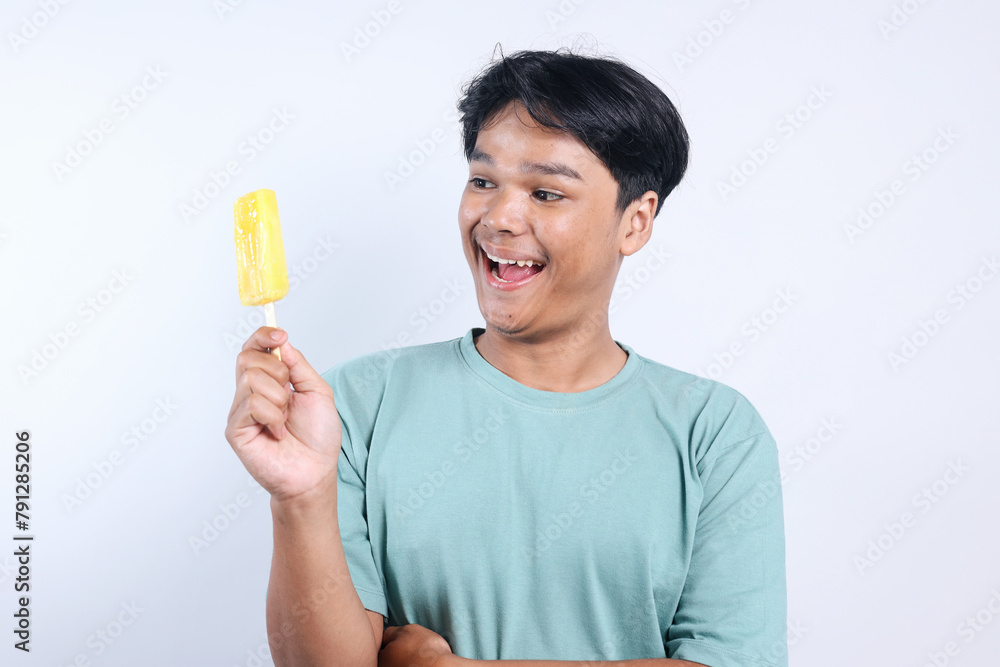 Excited Young Man Looking at Fresh Ice Cream Isolated on White Background Excited Young Man Looking at Fresh Ice Cream Isolated on White Background