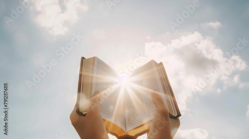 A person is holding a book open to a page with the sun shining on it. The scene is peaceful and serene, as the person is reading in a beautiful outdoor setting