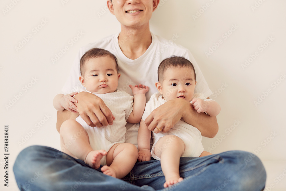 双子の赤ちゃんを抱く父親 双子の赤ちゃんを抱く父親