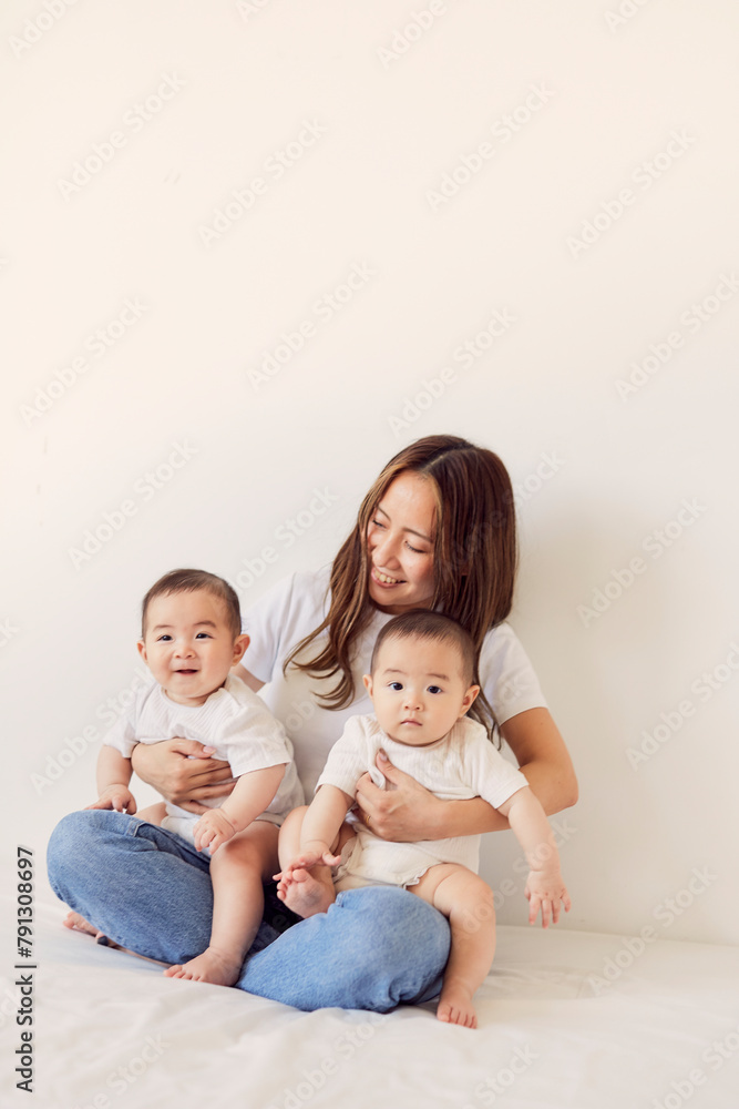双子の赤ちゃんを抱く母親 双子の赤ちゃんを抱く母親