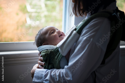 抱っこ紐に入って笑っている赤ちゃん photo