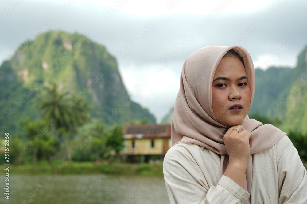Portrait of an Asian female model wearing a hijab at a tourist attraction posing