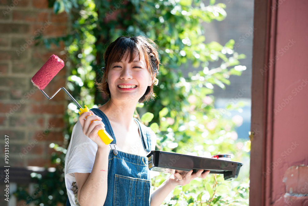 ペイントローラーを持って笑っている女性 ペイントローラーを持って笑っている女性