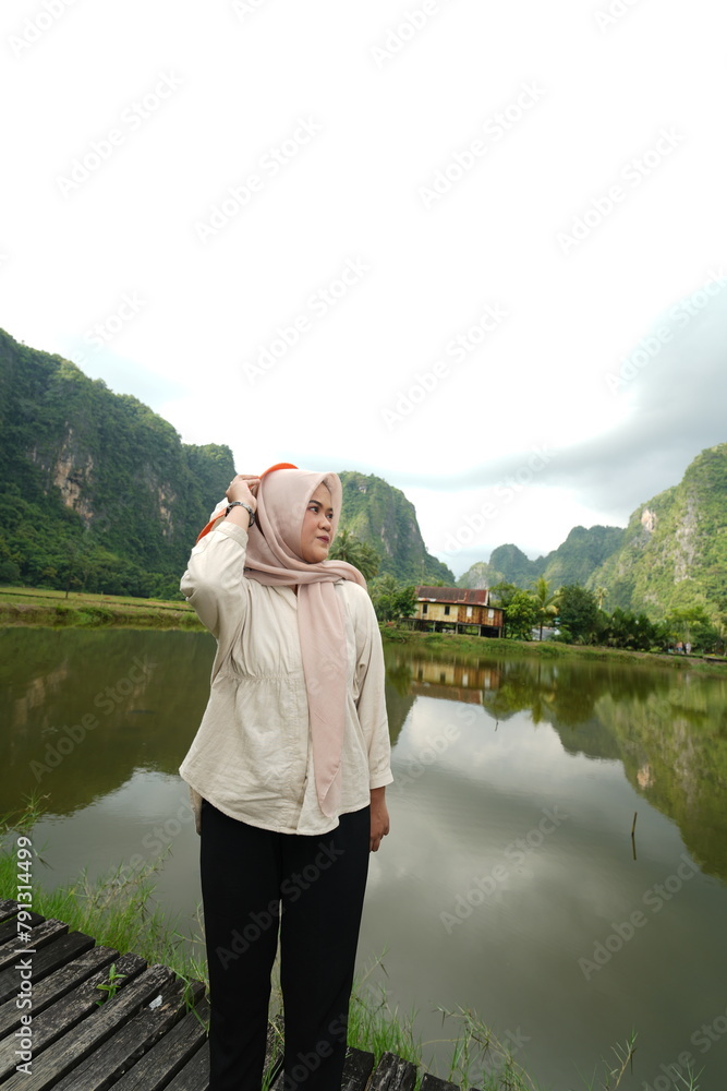 Portrait of an Asian female model wearing a hijab at a tourist attraction posing