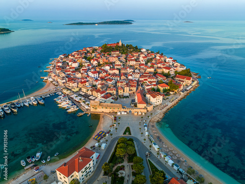 Primosten, Croatia - Aerial view of old town of Primosten peninsula, St. George's Church on a sunny summer morning in Dalmatia, Croatia. Blue and mooring yachts at sunrise on the Adriatic sea coast