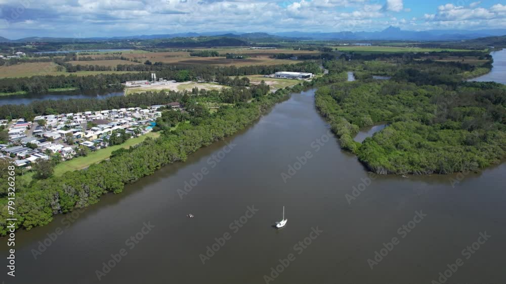 Sailboat On Tweed River Near Green Island In Chinderah, New South Wales, Australia. aerial sideways shot Sailboat On Tweed River Near Green Island In Chinderah, New South Wales, Australia. aerial sideways shot