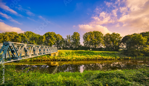 Laarbrug bridge spanning the Wilhelminakanaal canal near the village of Aarle-Rixtel, The Netherlands. Featuring blue sky and some sunset lit clouds. photo