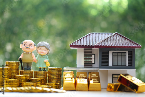 Mutual fund,Love couple senior on gold coin money and gold bar with model house on natural green background, Save money for prepare in future and pension retirement concept