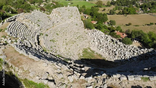 View from drone of ruins of Roman amphitheater at archaeological site of ancient city of Selge and picturesque surroundings on spring day, Altinkaya, Turkey photo