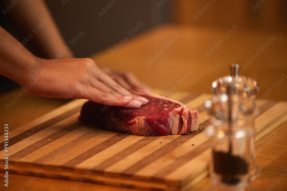 Kitchen, cooking and hands of person with steak for meal preparation at lunch, dinner and supper. Chef, ingredients and closeup of meat for protein diet, wellness and nutrition on counter in home