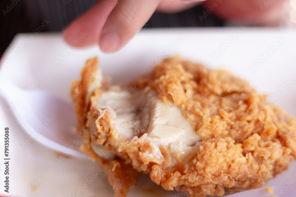 Woman eating fried chicken blurred background