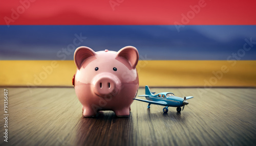 A piggy bank with an airplane against the backdrop of the Armenia flag. Saving money for vacations, leisure, and flights.